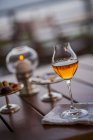 Vista da vicino del liquore in vetro di tulipano sul tavolo all'aperto — Foto stock