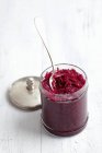 Pickled red cabbage with caraway in glass cup over white wooden surface — Stock Photo