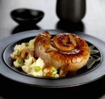 Cumberland sausage with onion — Stock Photo