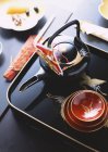 Elevated view of ornate Asian teapot with bowls on tray — Stock Photo