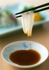 Squid sashimi and bowl of soy sauce — Stock Photo