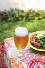 Beer and summer salad on plate — Stock Photo