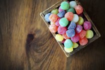 Colourful jelly sweets in wooden crate — Stock Photo