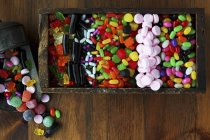 Top view of various colored sweets in wooden box — Stock Photo