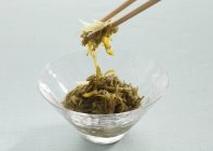Mekabu seaweed on chopsticks and in glass bowl — Stock Photo