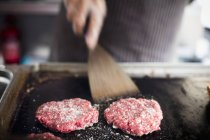 Hambúrgueres de carne bovina a serem virados — Fotografia de Stock