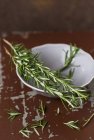 Spigs of rosemary and bowl — Stock Photo