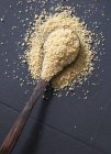 Raw couscous on a wooden spoon — Stock Photo