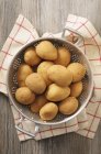 Patatas frescas en colador - foto de stock