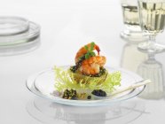 Uma batata nova com camarão e caviar em um prato de vidro — Fotografia de Stock