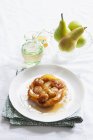 Tarte Tatin with shallots and pears  on white plate over towel — Stock Photo
