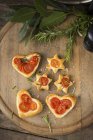 Coeurs de tomates et étoiles sur un bureau en bois — Photo de stock