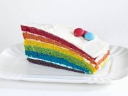 Rainbow cake with coloured chocolate beans — Stock Photo