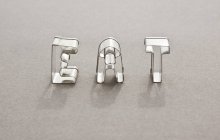 Vista de primer plano de la palabra EAT hecha con cortadores de galletas en forma de carta - foto de stock