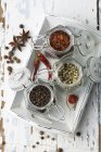 Various spices in storage jars on a tray on wooden surface — Stock Photo