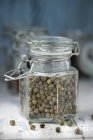 Pot en verre de grains de poivre séchés — Photo de stock