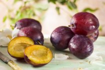 Fresh plums with halves — Stock Photo
