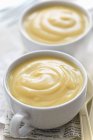 Vue rapprochée de deux tasses blanches de crème vanille — Photo de stock