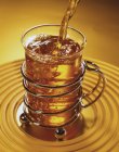 Nahaufnahme, wie man Tee in ein Teeglas gießt — Stockfoto