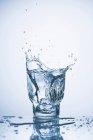 Água salpicando em um copo — Fotografia de Stock