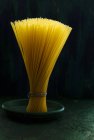 Bundle of spaghetti pasta on plate — Stock Photo