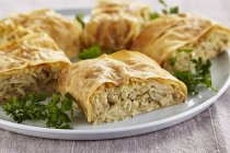Cabbage strudel  on white plate over wooden surface — Stock Photo