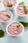 Closeup view of cranberry cream with mint leaves in bowls — Stock Photo