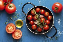 Cherry tomatoes with rosemary and olive oil — Stock Photo