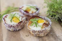 Baked eggs with bacon in paper cases — Stock Photo
