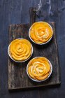 Almond tartlets with persimmon on desk — Stock Photo