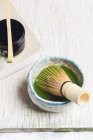 Closeup view of Matcha tea with whisk in bowl — Stock Photo