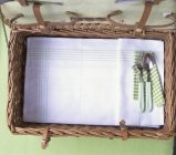 Top view of an open picnic basket with cutlery and a tea towel — Stock Photo