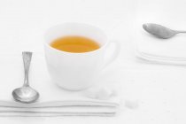 Cup of tea on white fabric napkin — Stock Photo
