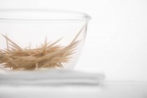 Closeup view of a glass bowl of toothpicks — Stock Photo