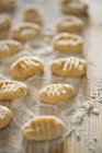 Closeup view of Gnocchi with flour on a wooden board — Stock Photo