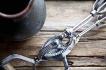 Closeup view of a vintage hand whisk near a clay jug — Stock Photo