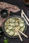 Grilled courgettes on black plate over black surface — Stock Photo