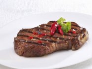 Fried beef steak with chilli peppers — Stock Photo