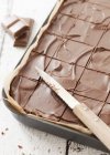 Closeup view of cut chocolate pie and knife on baking tray — Stock Photo