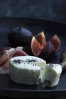 Goat's cheese on black plate — Stock Photo