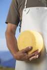 Cheesemaker with wheel of cheese — Stock Photo