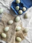 Белые яйца и голубая коробка с яйцами — стоковое фото