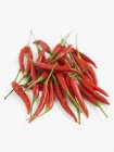 Red chilli peppers on white surface — Stock Photo