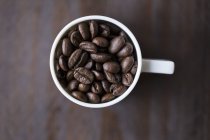 Granos de café en taza - foto de stock