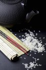 Bacchette, tappetino di bambù e riso — Foto stock