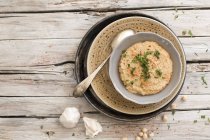 Hummus in a small bowl  over wooden surface — Stock Photo