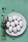 Белые яйца на тарелке с кексами — стоковое фото