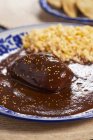 Closeup view of chicken with chocolate sauce and sesame — Stock Photo