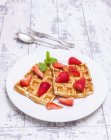 Waffles with strawberries on plate — Stock Photo