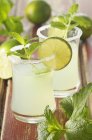 Mojito with lime slices and mint in glasses — Stock Photo
